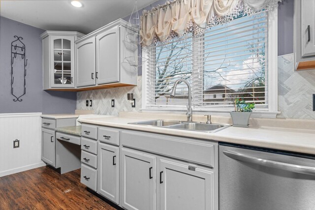 kitchen featuring tasteful backsplash, dark hardwood / wood-style flooring, dishwasher, and sink