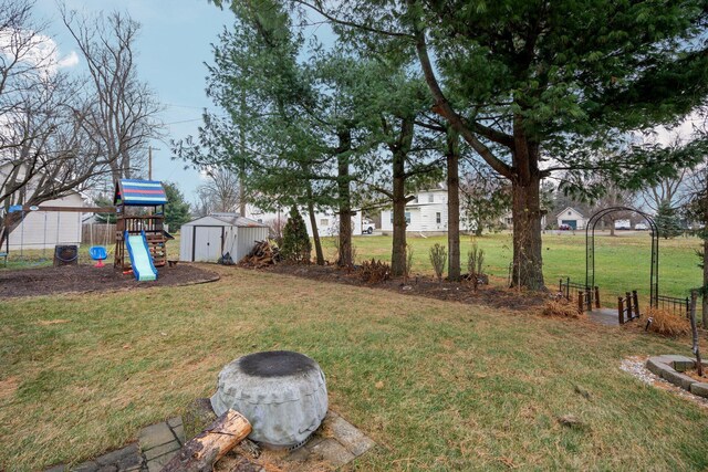 view of yard featuring a playground, ac unit, and a shed