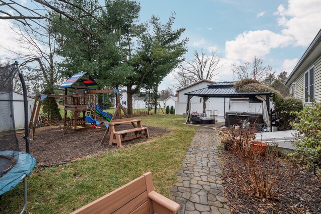 view of yard with a gazebo, a trampoline, a playground, and a hot tub