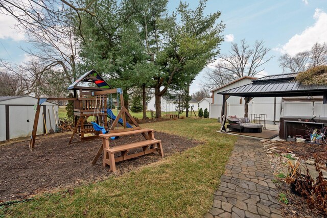 view of playground featuring a gazebo, a yard, and a hot tub