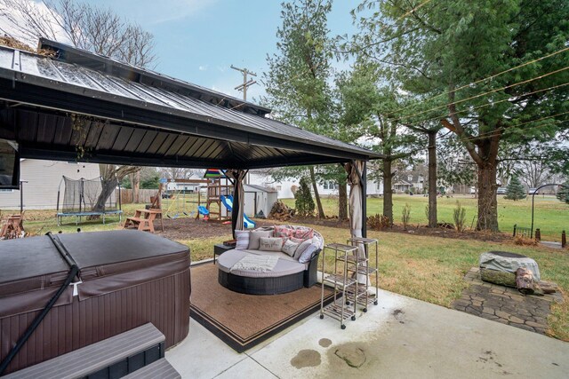 view of patio featuring a playground, a trampoline, and a hot tub