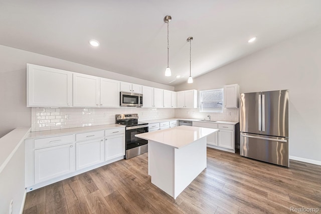 172 Woodland Way, Manchester, MI 48158 - kitchen featuring stainless steel appliances, decorative backsplash, white cabinetry, lofted ceiling, and wood finished floors