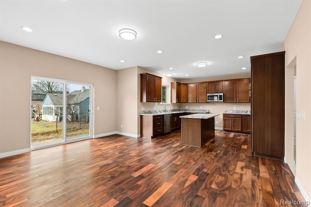 kitchen with dark hardwood / wood-style flooring, a kitchen island, stainless steel appliances, and sink