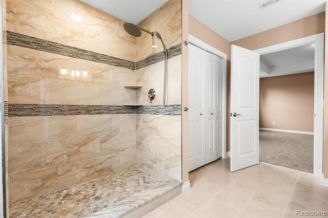 bathroom with tiled shower and tile patterned floors