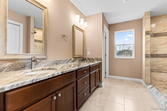 bathroom with tile patterned flooring, vanity, and walk in shower