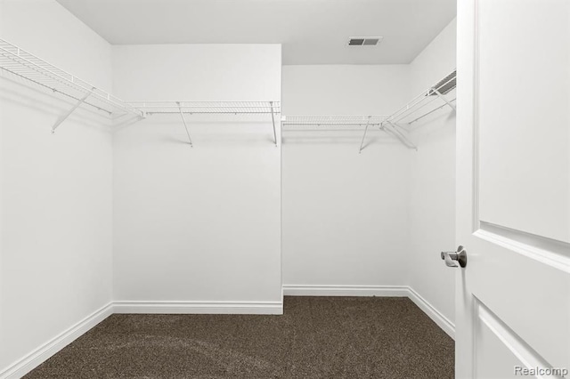 spacious closet featuring dark carpet