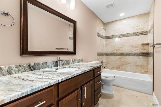 full bathroom with toilet, vanity, and tiled shower / bath