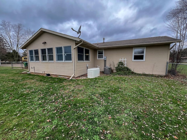 back of property with a yard and central AC unit