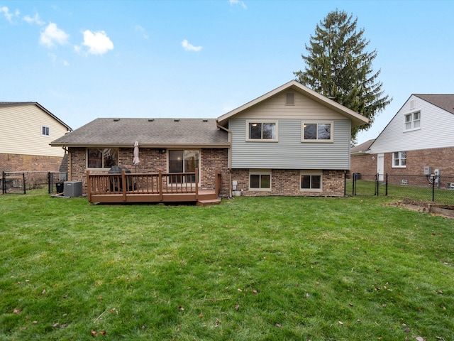 back of property with a deck, cooling unit, and a lawn