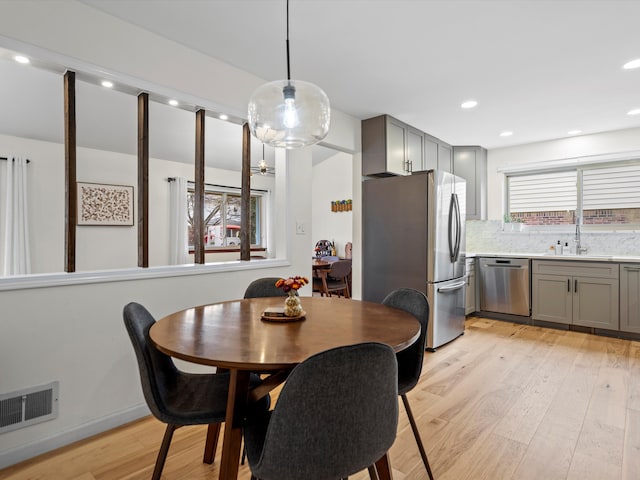 dining space with sink and light wood-type flooring