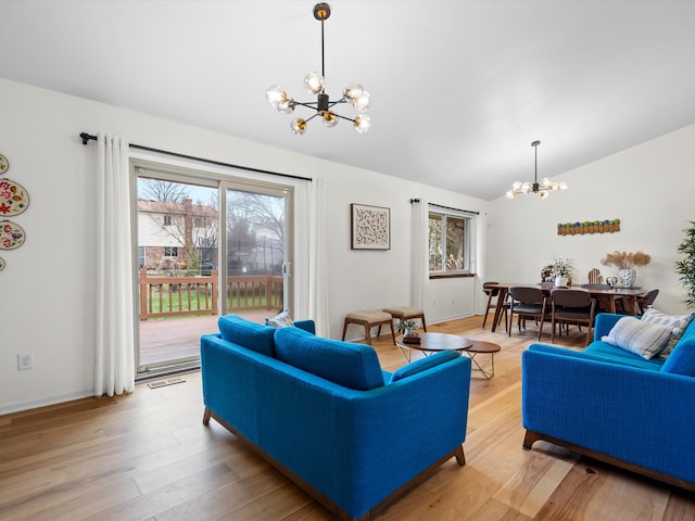 living room featuring lofted ceiling, light hardwood / wood-style flooring, and a chandelier