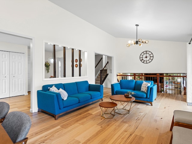 living room with a chandelier, lofted ceiling, and hardwood / wood-style flooring