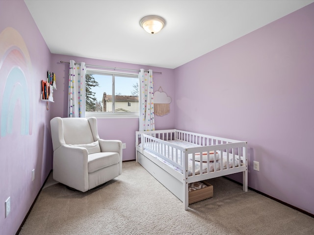 bedroom featuring light carpet and a nursery area