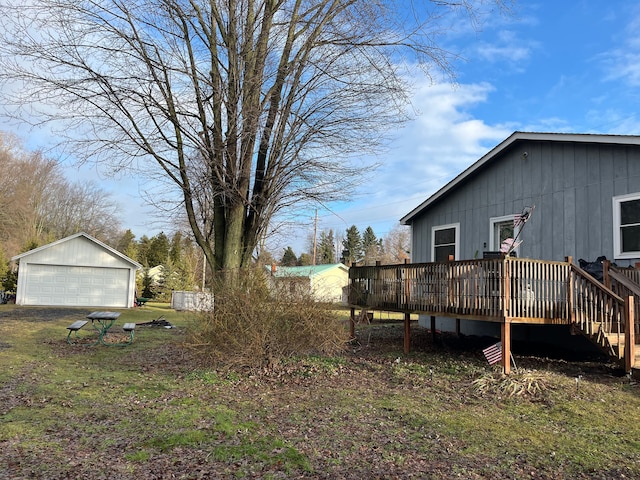 view of yard with a garage, an outdoor structure, and a wooden deck