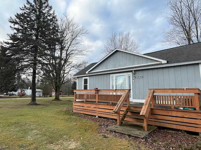 rear view of house featuring a lawn and a wooden deck