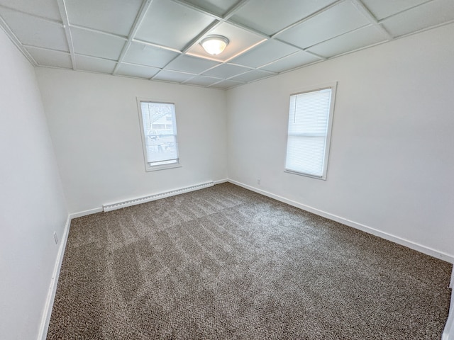 carpeted spare room featuring a baseboard heating unit