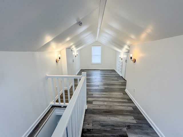 hall featuring dark wood-type flooring and vaulted ceiling