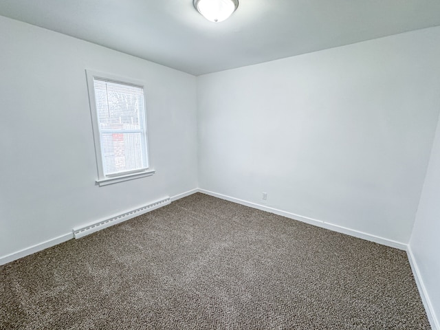 empty room with carpet flooring and baseboard heating