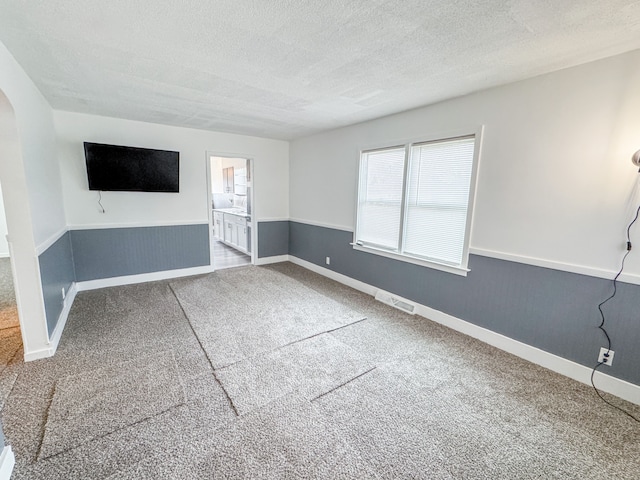 unfurnished living room with carpet and a textured ceiling