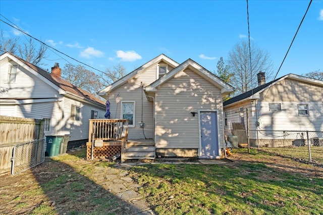 rear view of property featuring a lawn and a wooden deck