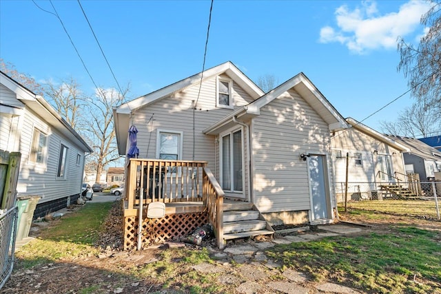 back of house with a deck and a lawn