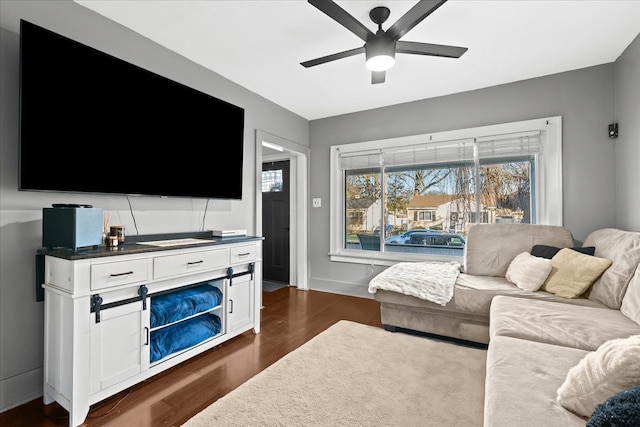 living room featuring ceiling fan and dark wood-type flooring