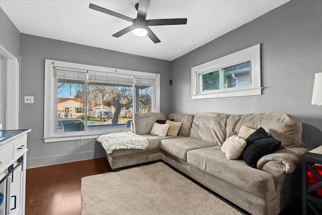 living room with ceiling fan and dark wood-type flooring