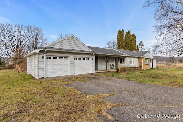 1193 N State Rd, Ionia, MI 48846 - ranch-style home featuring a porch, a front yard, and a garage