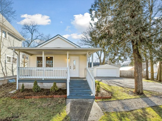 bungalow-style home with an outbuilding, a garage, and covered porch