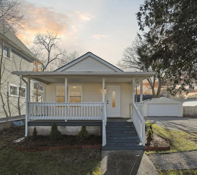 view of front of property featuring covered porch, an outdoor structure, and a garage