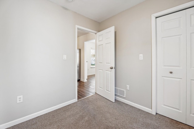 unfurnished bedroom featuring carpet floors and a closet