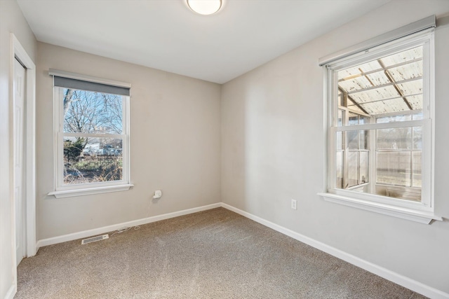 unfurnished room featuring plenty of natural light and carpet floors