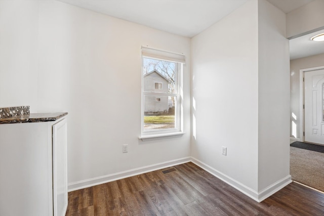 unfurnished dining area with dark hardwood / wood-style flooring