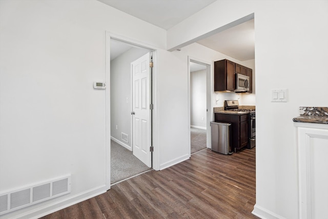 kitchen with dark hardwood / wood-style floors, dark brown cabinetry, and stainless steel appliances