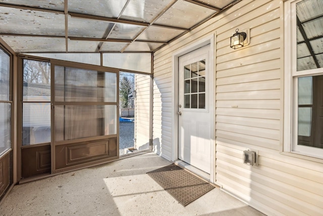 unfurnished sunroom featuring vaulted ceiling