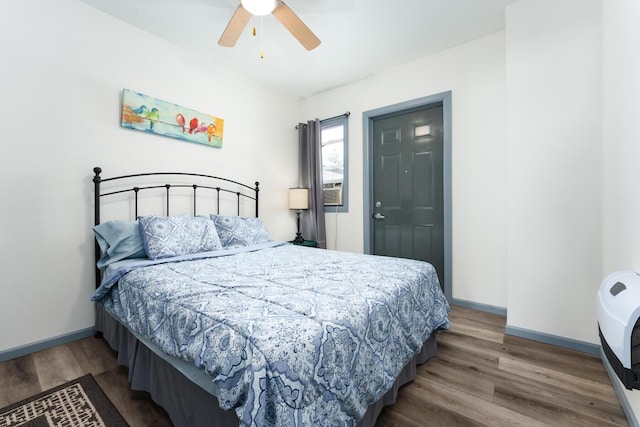 bedroom featuring wood-type flooring, heating unit, and ceiling fan