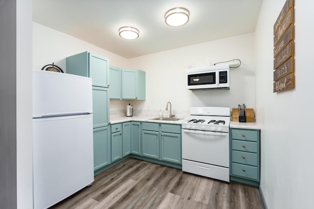 kitchen featuring dark hardwood / wood-style flooring, white appliances, and sink