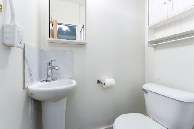 bathroom featuring decorative backsplash and toilet