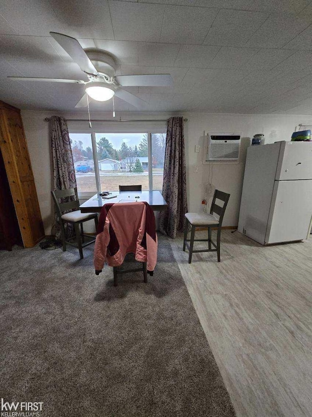 carpeted dining space with an AC wall unit and ceiling fan