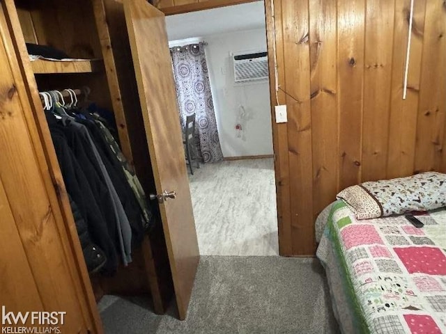 carpeted bedroom featuring a wall unit AC and a closet