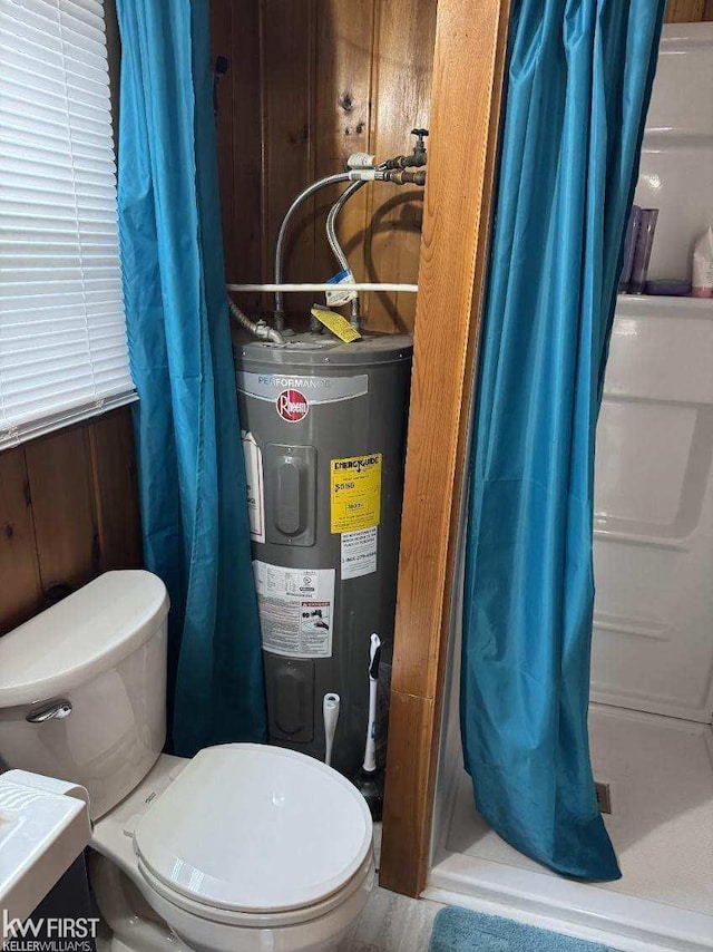 bathroom featuring wood walls, curtained shower, toilet, and water heater