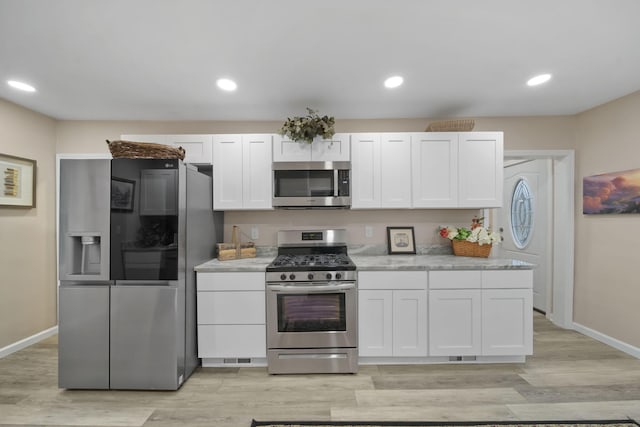 kitchen featuring light hardwood / wood-style floors, white cabinetry, and appliances with stainless steel finishes