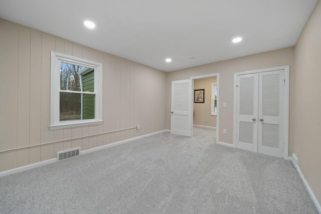 unfurnished bedroom featuring light carpet and a closet