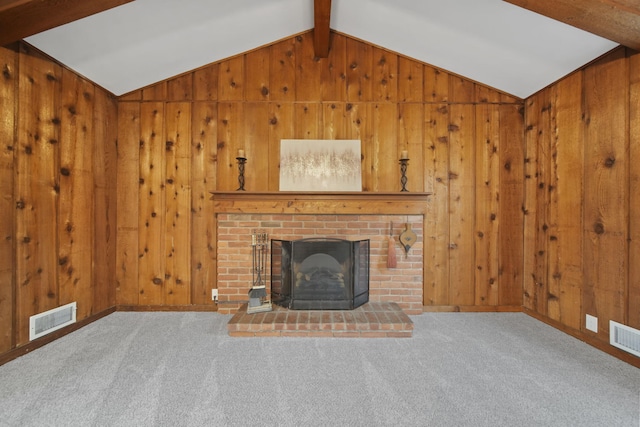 unfurnished living room featuring carpet flooring, lofted ceiling with beams, and wood walls