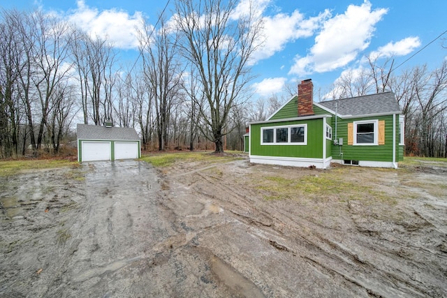 view of property exterior with a garage and an outbuilding