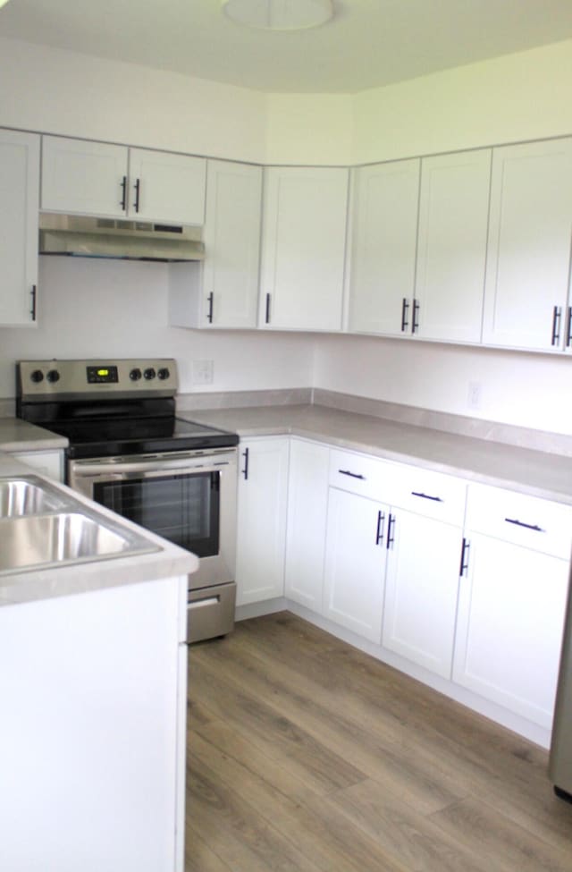 kitchen with stainless steel range with electric stovetop, white cabinetry, and light hardwood / wood-style flooring