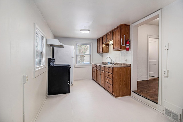 kitchen featuring decorative backsplash, black range with electric cooktop, extractor fan, and sink