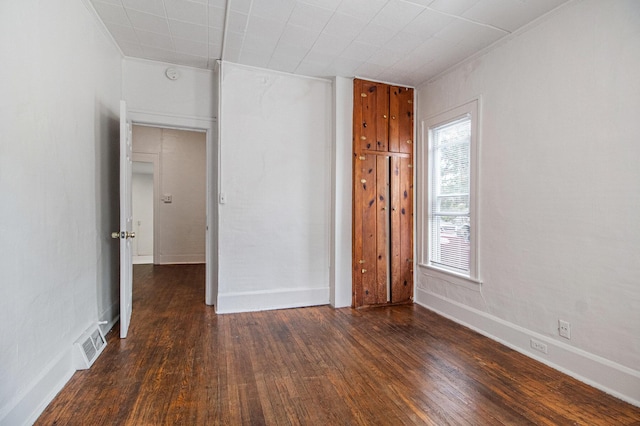 unfurnished bedroom with dark hardwood / wood-style floors and a closet