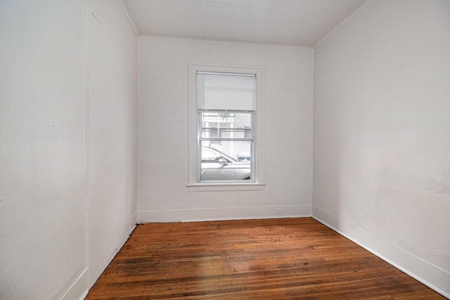 unfurnished room featuring ornamental molding and dark wood-type flooring