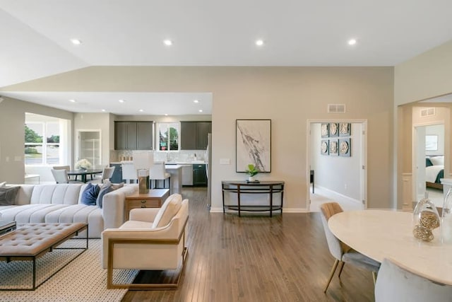 living room featuring wood-type flooring and vaulted ceiling